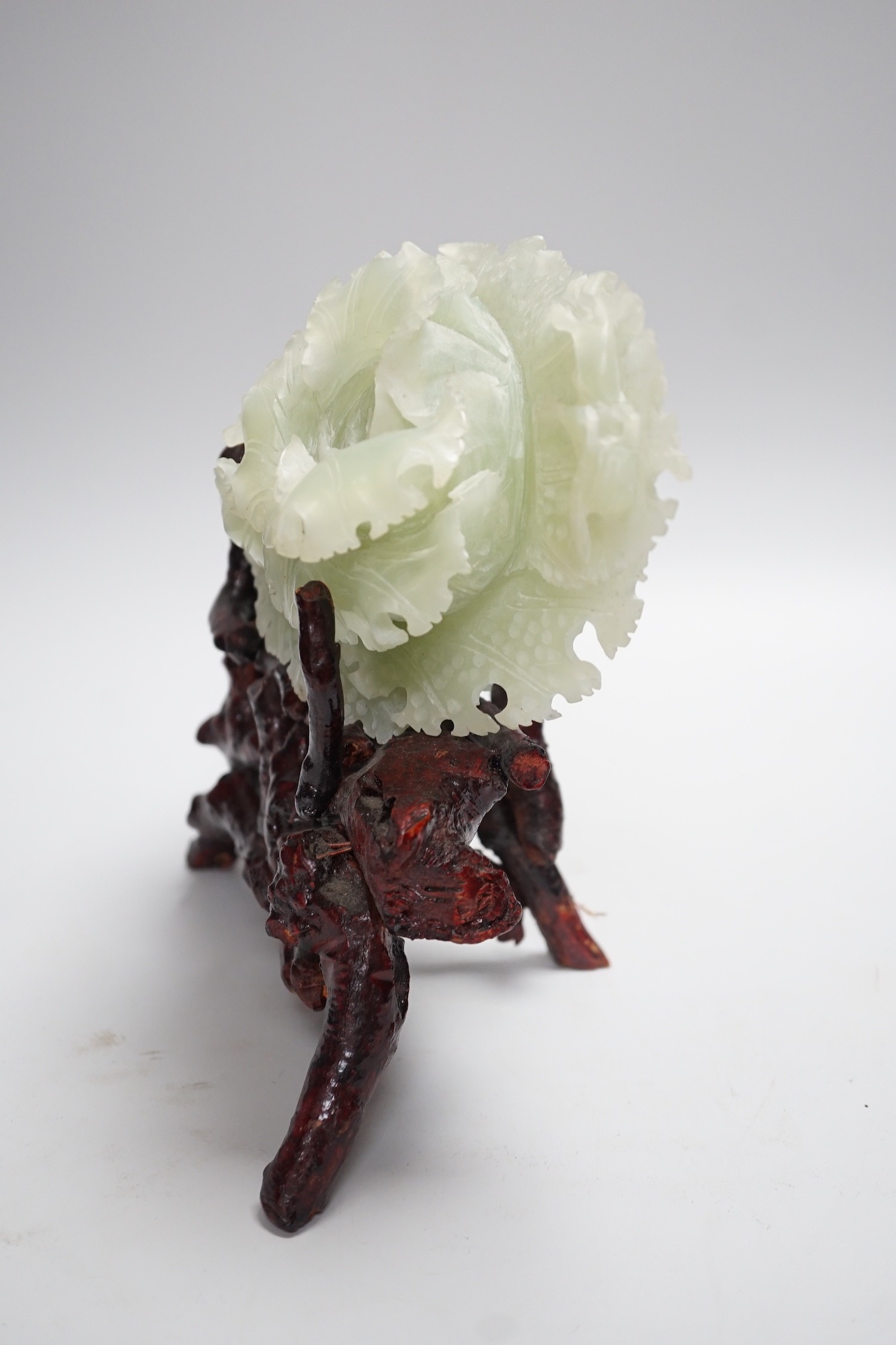 A Chinese bowenite jade carving of a cabbage and a rootwood stand, overall height 24cm